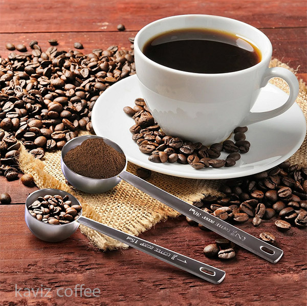 فنجان قهوه و دانه های قهوه وقهوه آسیاب شده داخل قاشق