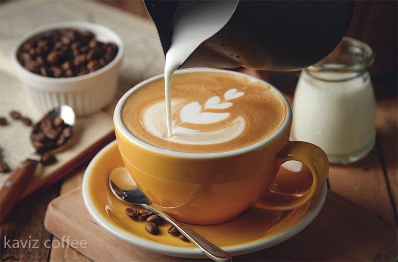 ریختن شیر روی فنجان قهوه و دانه های قهوه