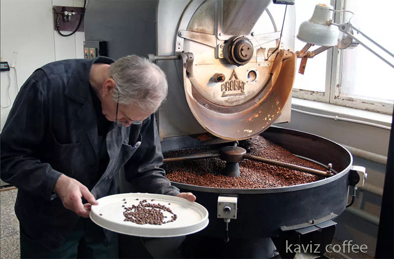 دستگاه رستر قهوه و آقایی در حال بررسی دانه های قهوه