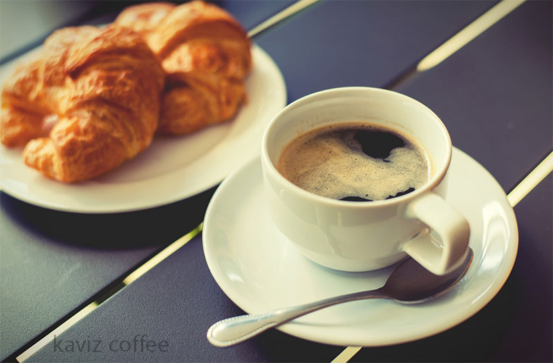 یک فنجان قهوه ناشتا و کیک کروسان